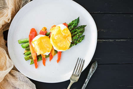 Poached egg with hollandaise sauce over asparagusの写真素材