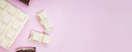 White and black chocolate bars and pieces on pink background, top viewの写真素材