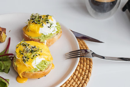 Poached eggs over the bread bun with mashed avocado.