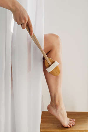 Woman doing self massage with cosmetic dry brushの写真素材