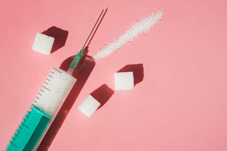 Syringe with granulated sugar inside on pink backgroundの写真素材