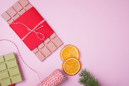 Chocolate bars of pink and green color in red wrap on pink background