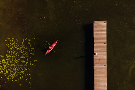 Woman in a canoe over green water crossing the river.