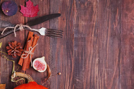 Autumn table setting with figs and dry leaves on wooden tableの写真素材