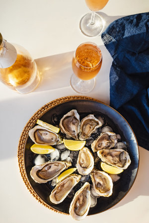 Plate full of fresh oysters with lemon and rose sparkling wine