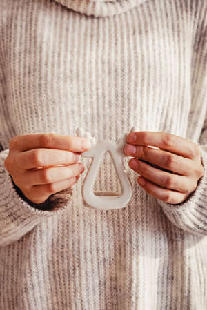 Feminine hands holding a deer shaped candlestick close-up.の写真素材
