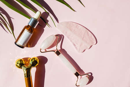 Different tools for face massage and bottle of face care moisturizing serum.の写真素材