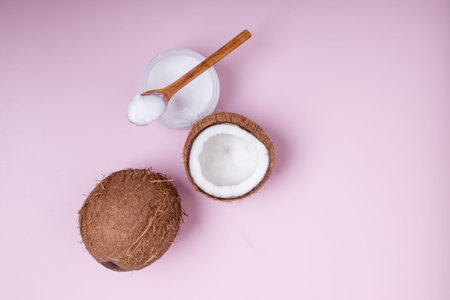 Coconuts on pink background, top view.