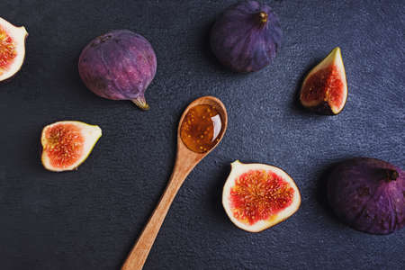Fig jam in a wooden spoon and fresh figsの写真素材