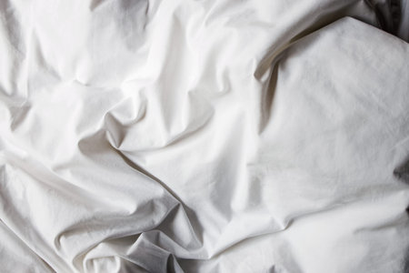 Crumpled white cotton bed sheet close up