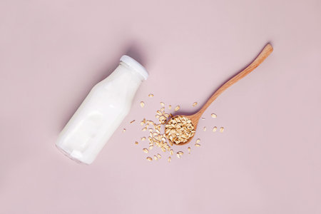 Bottle of non dairy oat milk on pink background