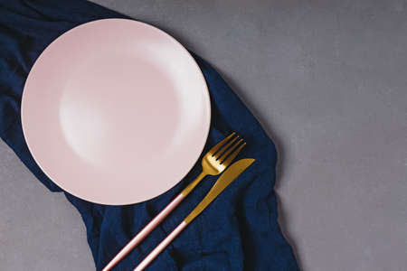 Empty pink plate on dark grey tableの写真素材