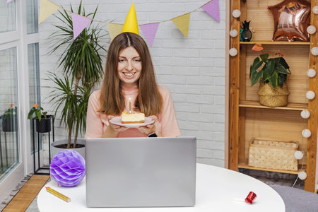 Woman celebrating her birthday at home and communicate with friends by video chat