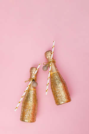 Mini bottles of champagne decorated with golden glitter and paper strawsの写真素材