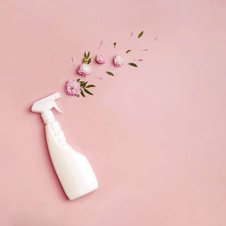 Plastic bottle with cleaning spray and flowers on pink background.の写真素材
