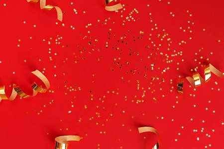 Golden swirls and star shaped sparkles on redの写真素材