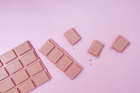 Bar and pieces of pink chocolateの写真素材