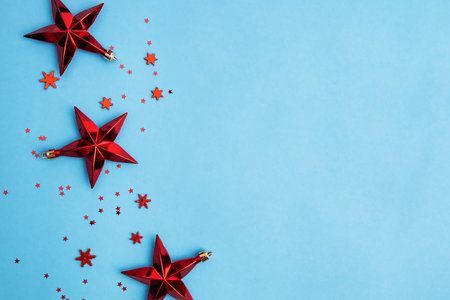Red Christmas stars and snowflakes on blue background.