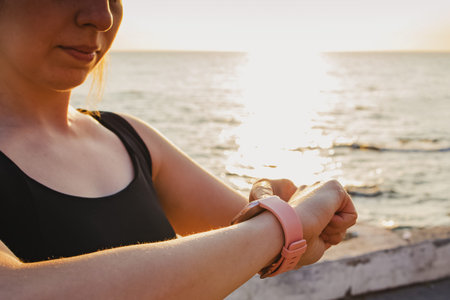 Young woman checking her heart rate at fitness tracker.