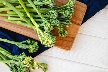 Raw broccolini green vegetable on wooden board. Healthy organic food, top viewの写真素材