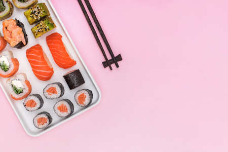 Sushi set with salmon on pink background, top view. Minimalist flat lay compositionの写真素材