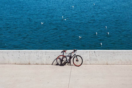 Bike parked seafront with blue sea and seagulls on the backgroundの写真素材