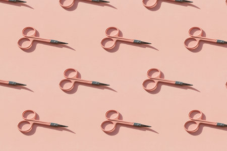Cosmetic scissors on pink background.