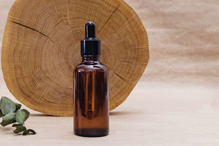 Bottle with face serum and wooden saw cutの写真素材