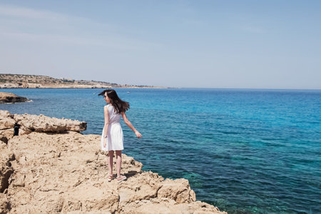 Woman in light dress enjoying being by the sea.の写真素材
