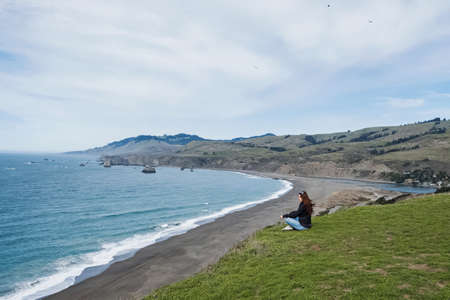 Woman sitting with a view to the oceanの写真素材