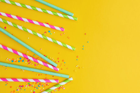 Multicolored party drinking straws and sugar sprinkles