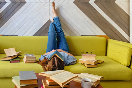 Young woman reading on the sofa at the living roomの写真素材