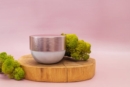 Jar of hydrating cream or other beauty product on wooden saw cut.