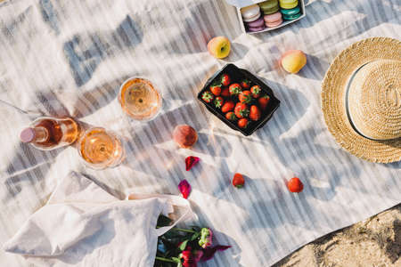 Rose wine, peaches and strawberries on the beach.の写真素材