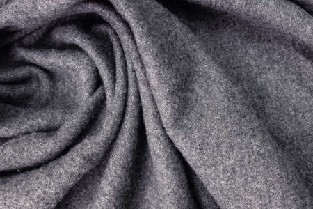 Grey soft woolen cozy scarf texture close-up.の写真素材