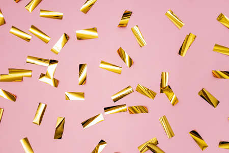 Golden shiny confetti on pink background, festive backdropの写真素材