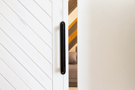 Small gap between white wooden sliding door and wall with room on the backgroundの写真素材