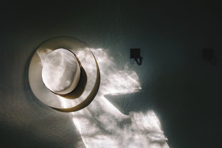 White hat hanging on the wall in the morning light. Minimalist modern interiorの写真素材