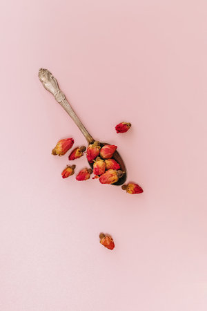 Dry pink rose buds in the spoon, top view. Herbal tea ingredient.の写真素材