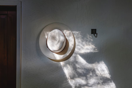 White hat hanging on the wall in the morning light. Minimalist modern interiorの写真素材