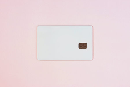 Photo mock-up of white credit card with chip on pink background, top view
