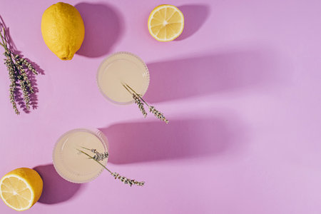 Lavender lemonade and lemons on the purple background with long shadows, top viewの写真素材