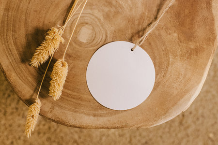 Circle paper on wood side table, gift tag, label mock-up in natural lightの写真素材