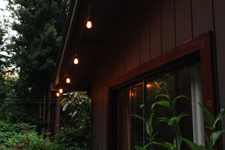 Cozy wooden cabin in the woods with warm light garland lights