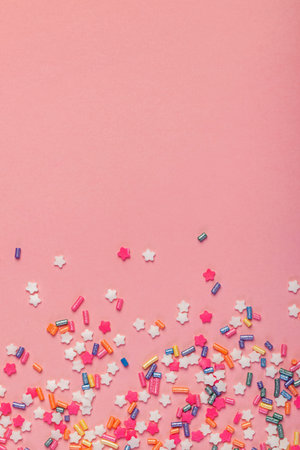 Colorful star shaped sugar sprinkles on pink background, party backdropの写真素材