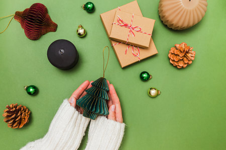 Female hands holding Christmas decor made of paper, preparing for holidays, view from the topの写真素材