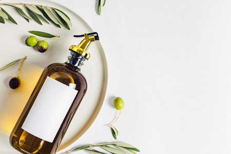 Olive oil in elegant bottle and leaves, top viewの写真素材