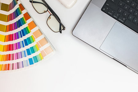 Designer workplace, top view. Laptop, glasses and color swatches on the white tableの写真素材