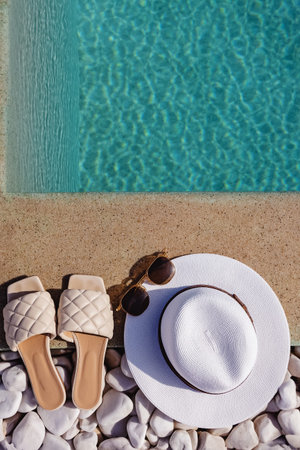 Hat, sunglasses and sandals by the pool