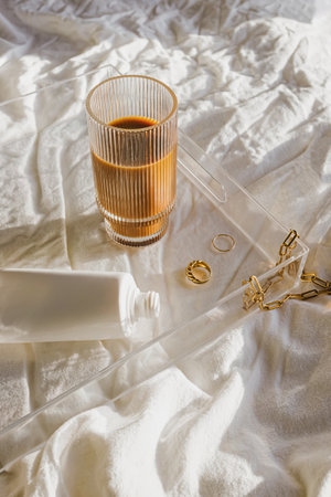 Iced coffee and jewelry on the tray, morning routine aesthetic still life in natural lightの写真素材